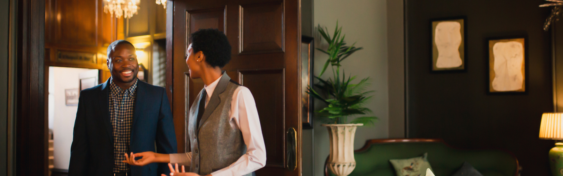 a woman in a vest standing in front of a door