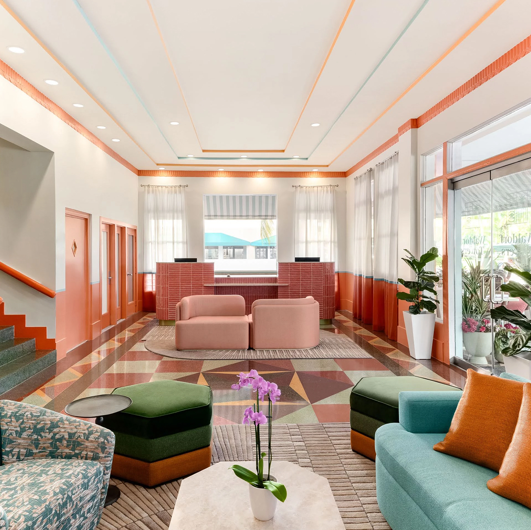 a lobby with colorful furniture and a flower pot expanded