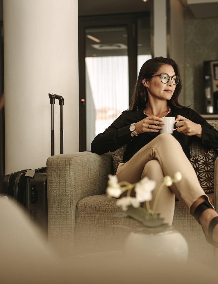 a woman sitting on a couch holding a cup