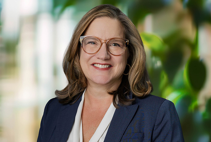a woman wearing glasses and a blue suit