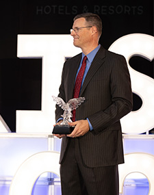 a man in a suit holding a trophy
