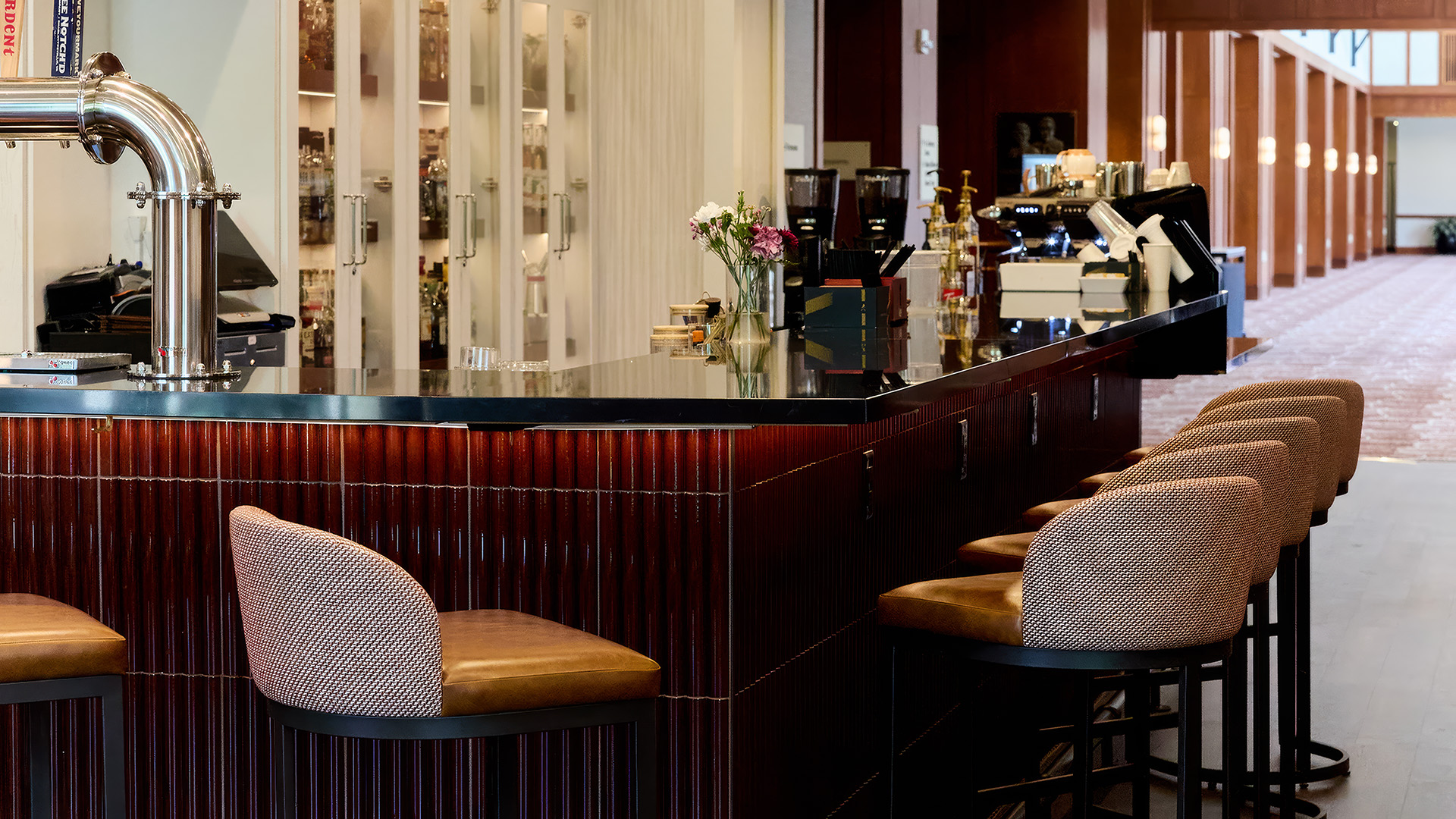 a bar with chairs and a vase of flowers