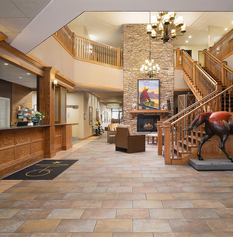 a lobby with a statue of a horse and a fireplace