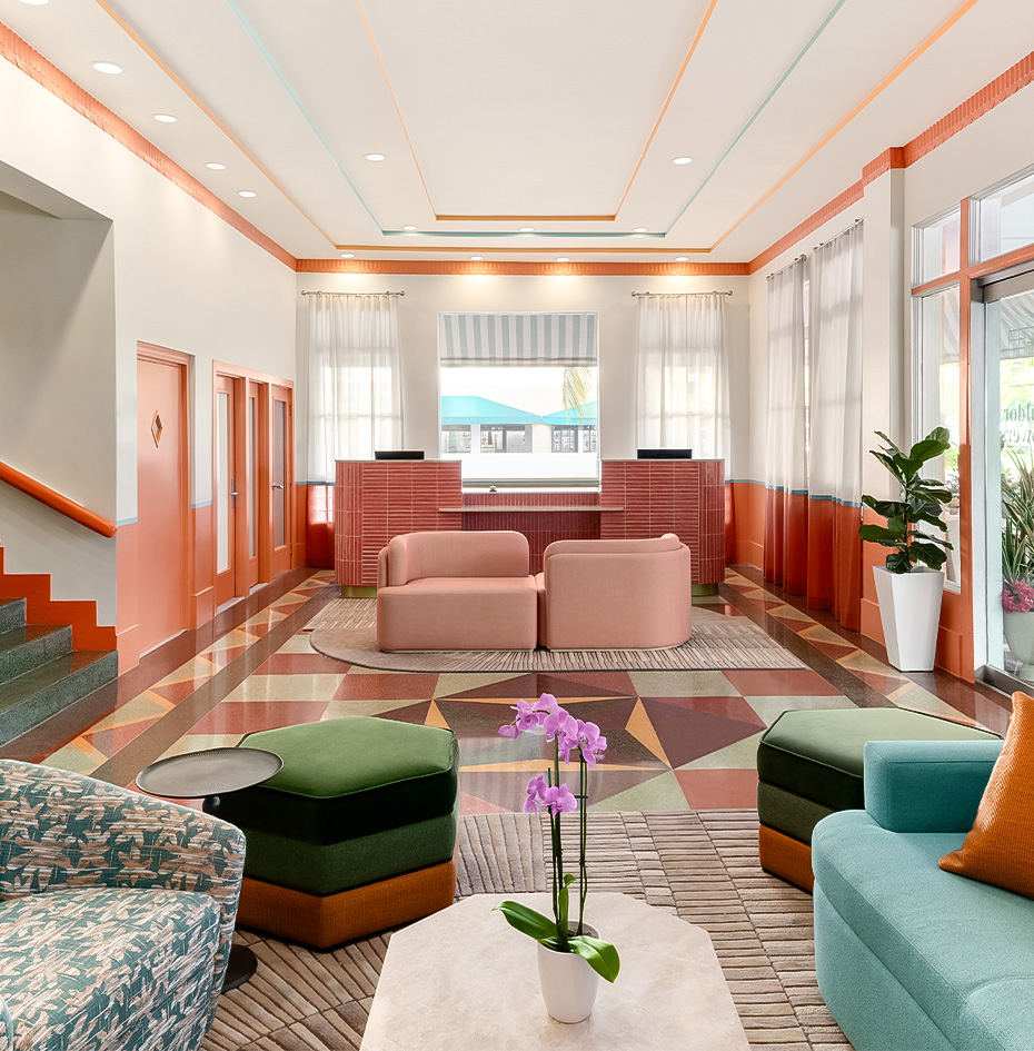 a lobby with colorful couches and a flower pot