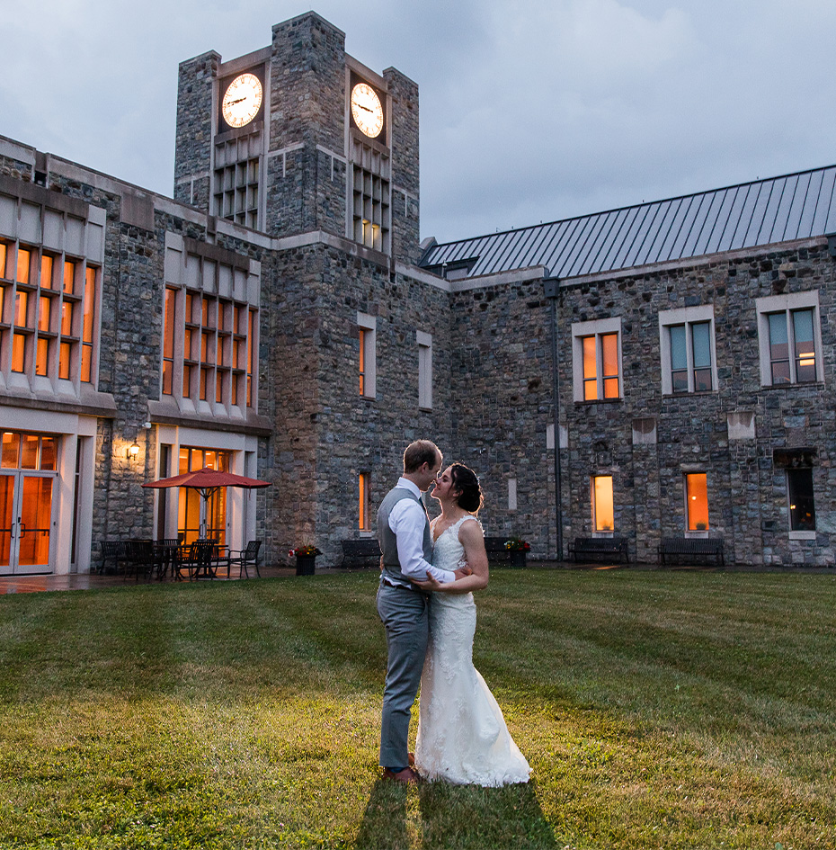 a man and woman in front of a stone building