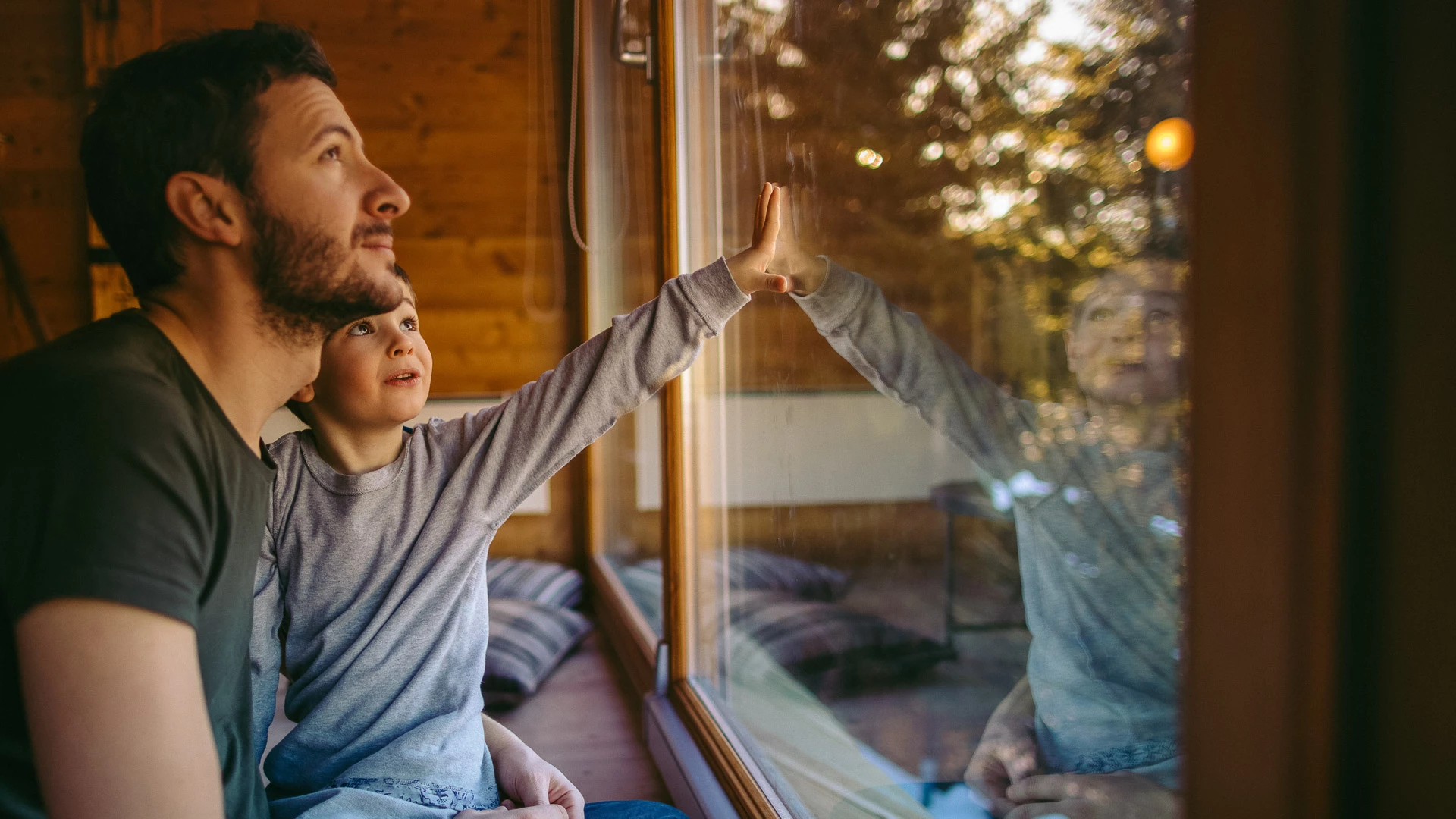 a man and child looking out a window