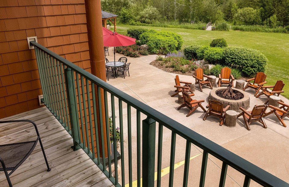 a patio with chairs and a fire pit
