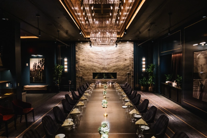 a long table with chairs and plates on it