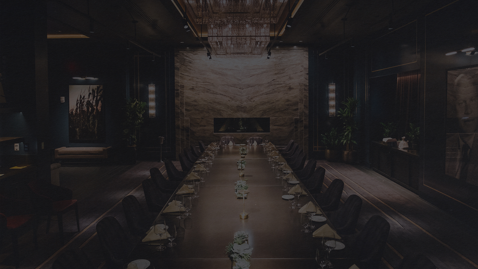 a long table with chairs and a chandelier