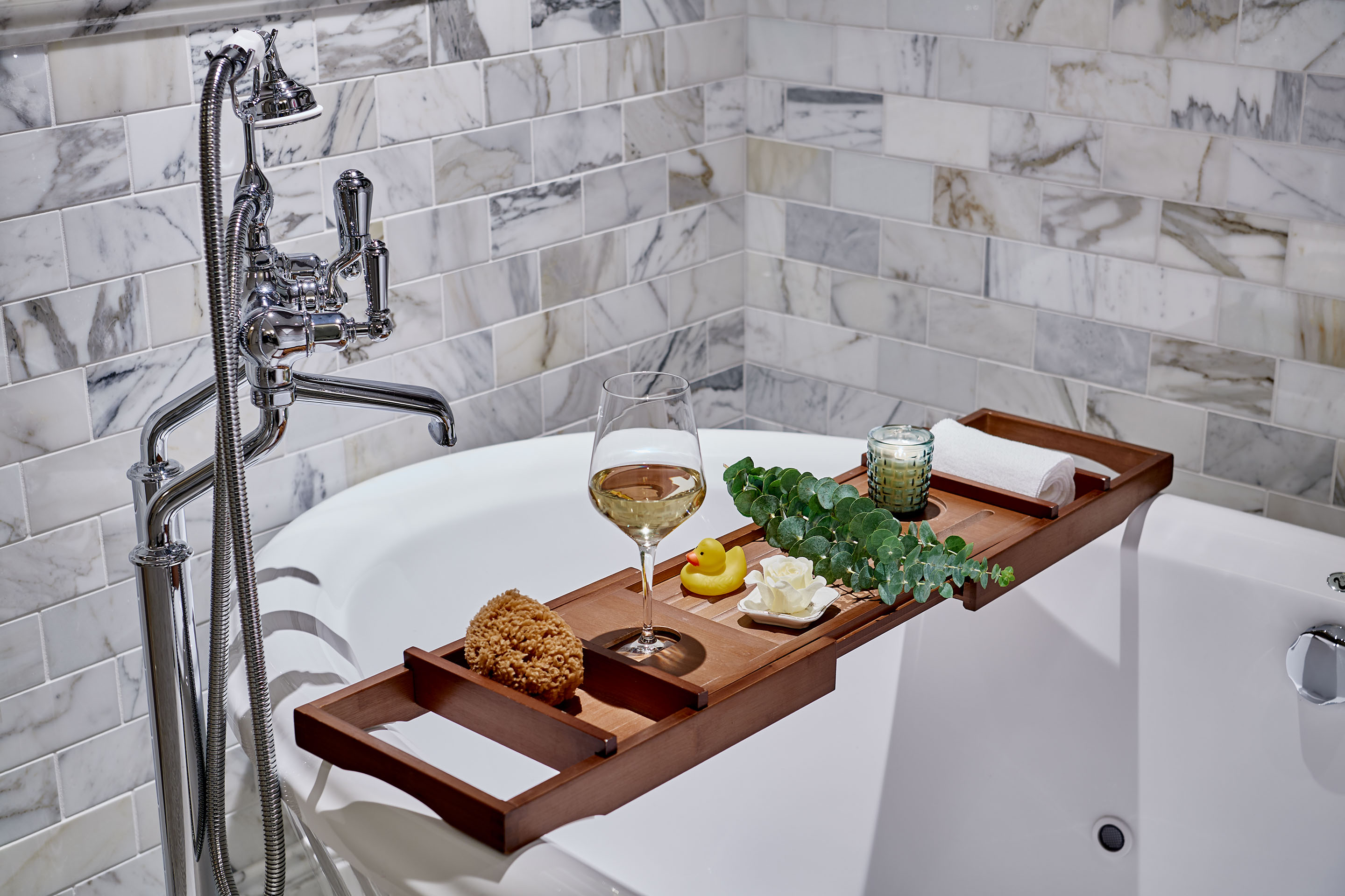 a tray with food and wine on it in a bathtub