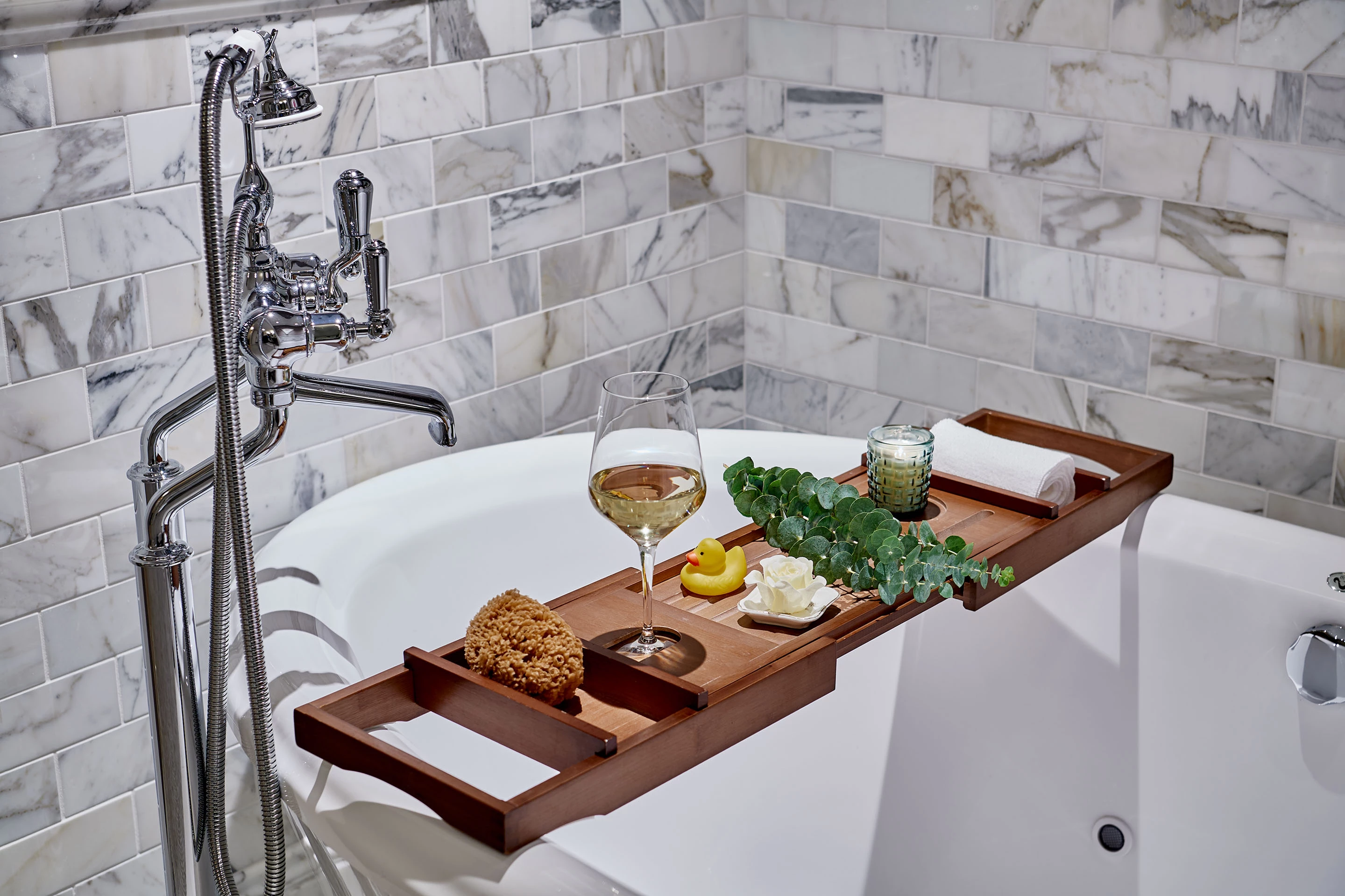 a tray with food and wine on it in a bathtub