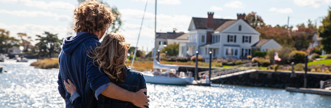 a man and woman hugging by water