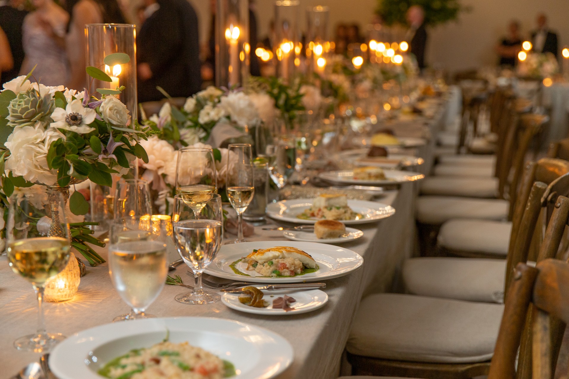 a long table with plates of food and wine glasses