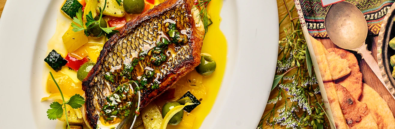 a plate of food with a piece of fish and vegetables