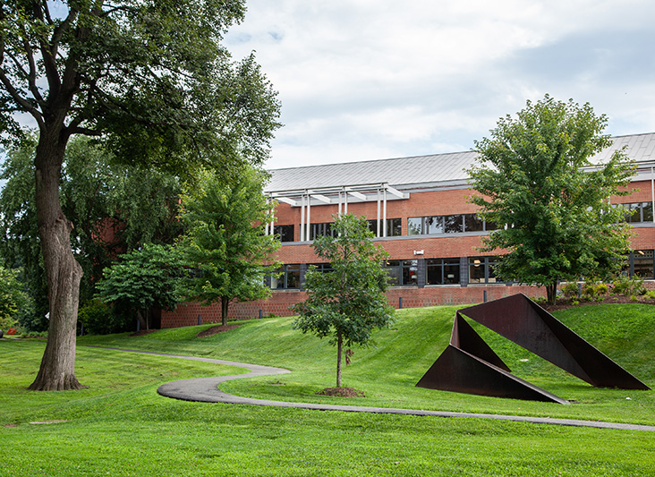 a building with a large metal sculpture in the middle of a grassy area