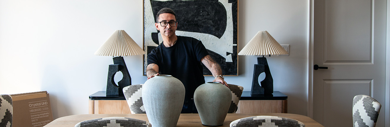 a man standing in front of a table with vases