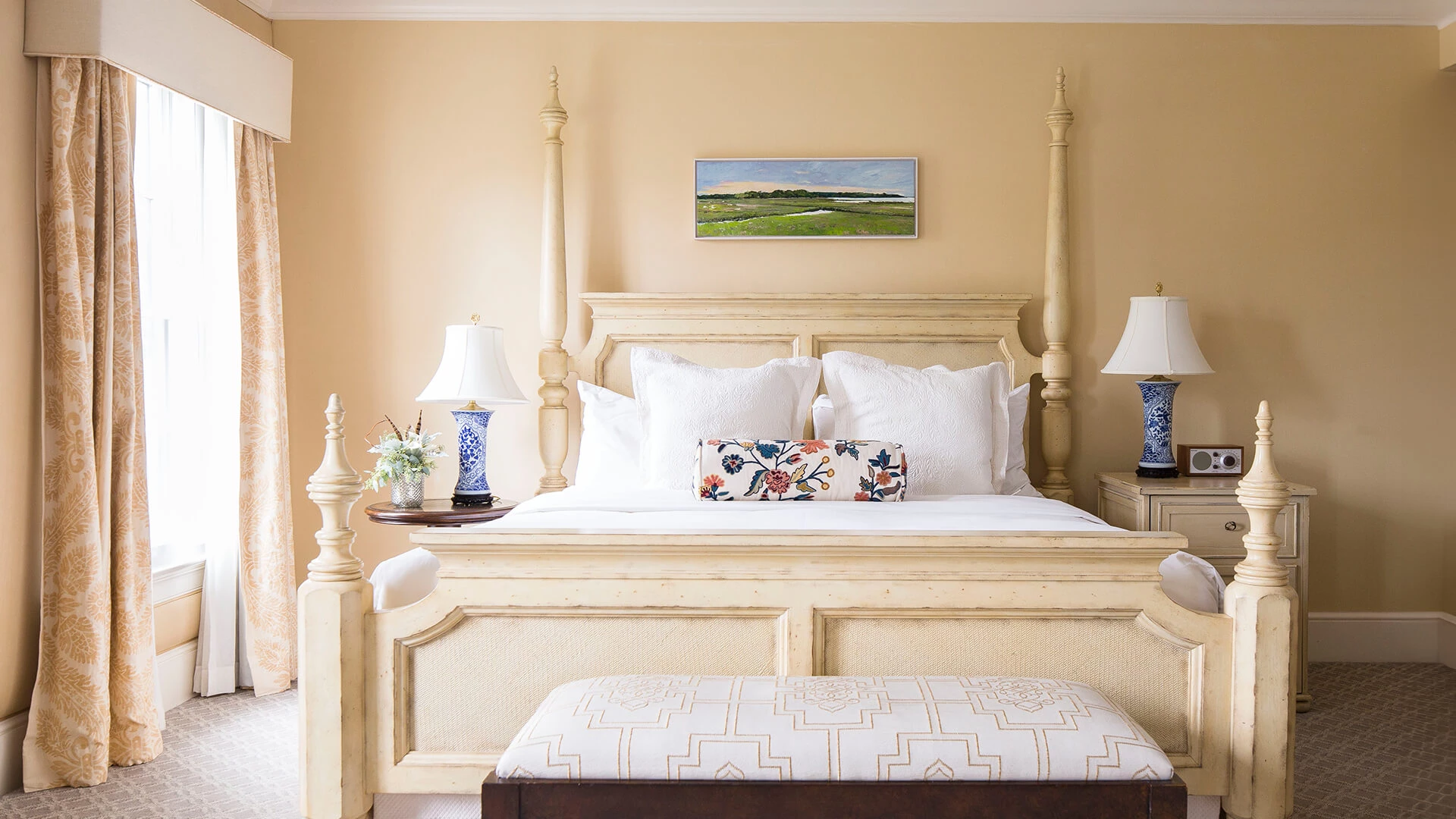 A wide view of a hotel room with a large bed, two nightstands, and a window