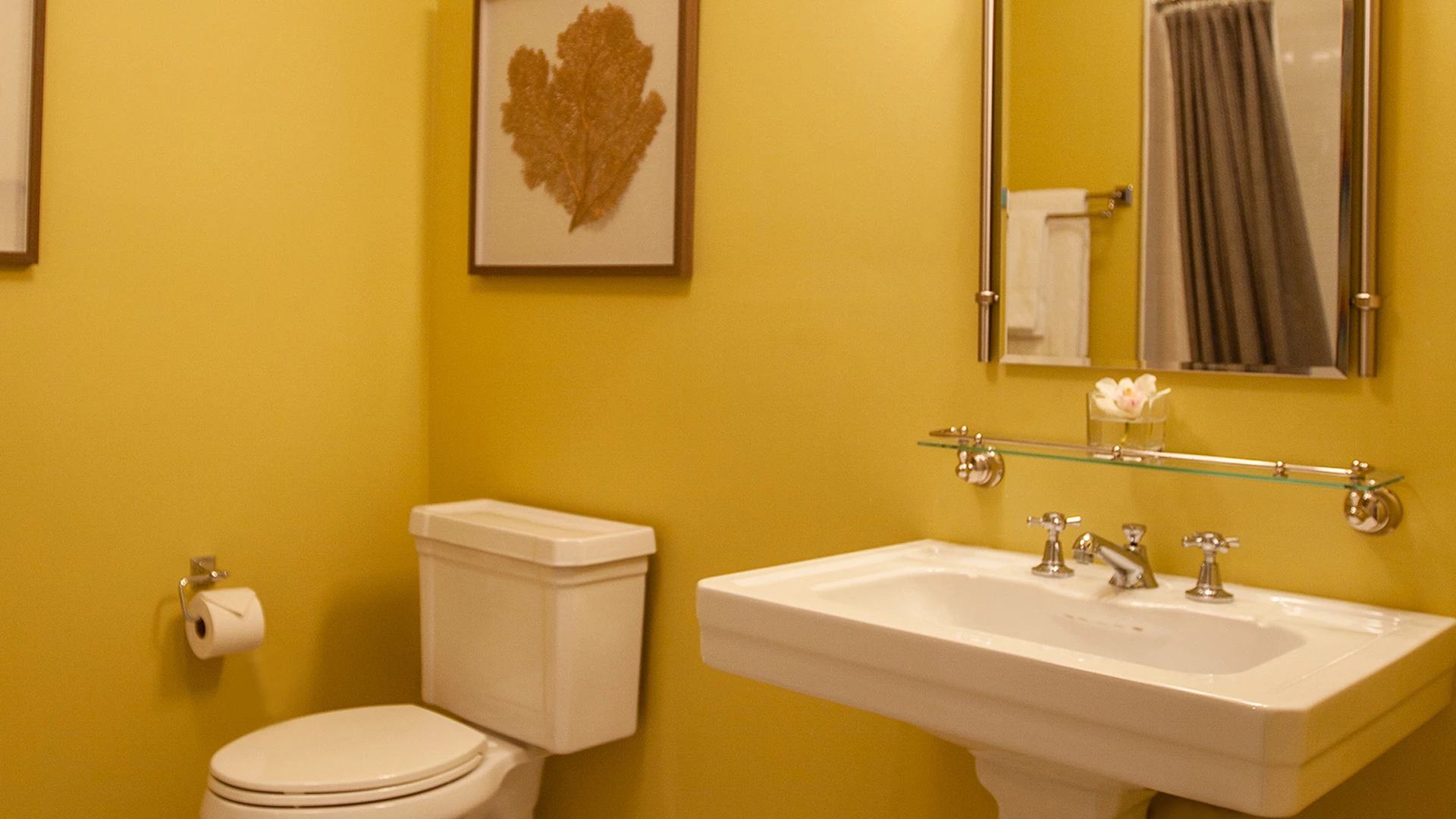 A bathroom with a toilet, washbasin, and mirror