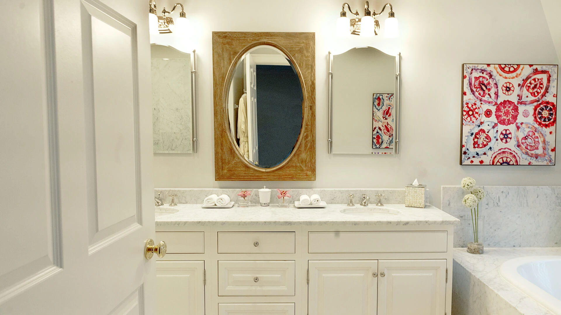 A clean and well-appointed bathroom with a double vanity, marble countertop, and large mirror.