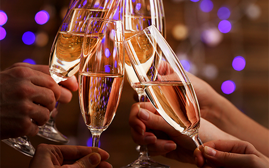 a group of hands holding champagne glasses