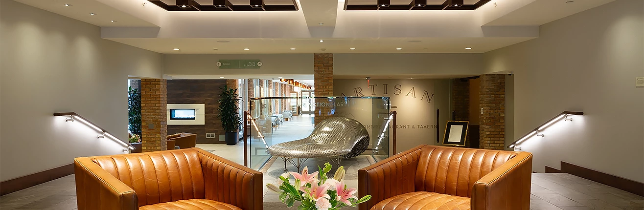 a room with a glass wall and a vase of flowers