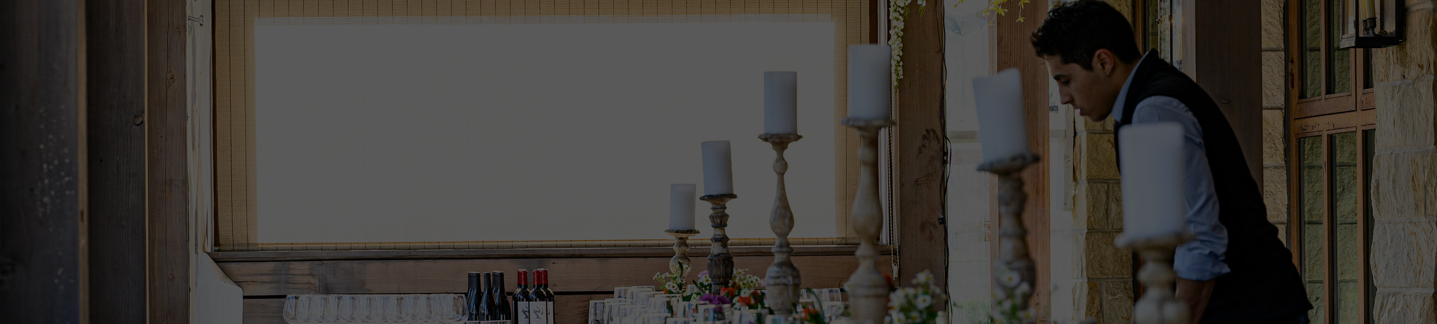a person standing in a room that has a table with candles on it