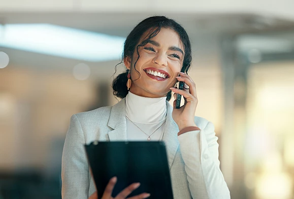 a woman holding a clipboard and talking on the phone