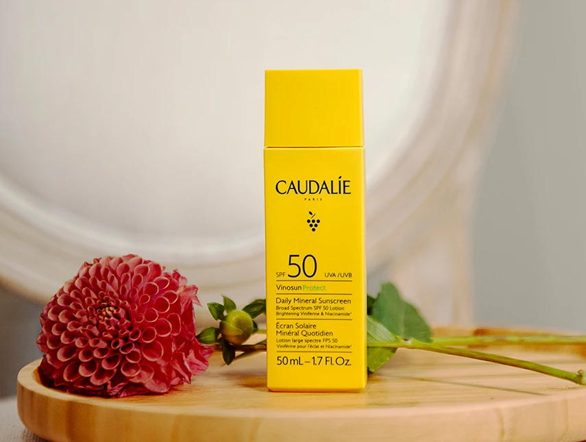 a yellow box with black text next to a pink flower