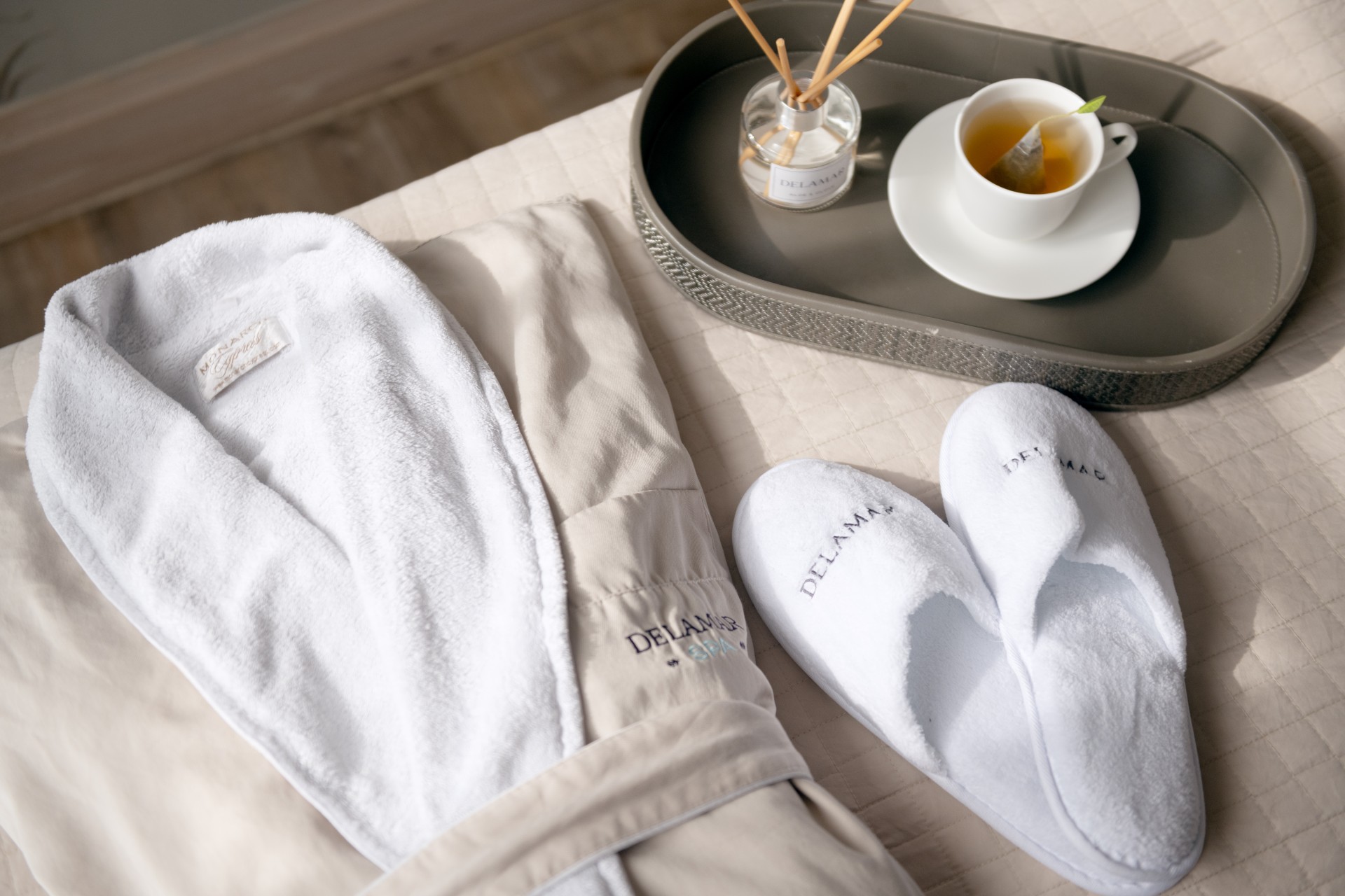 a bathrobe and slippers on a bed