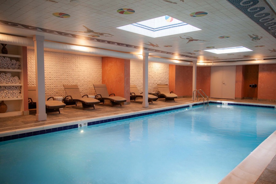 a pool with lounge chairs and a ceiling light