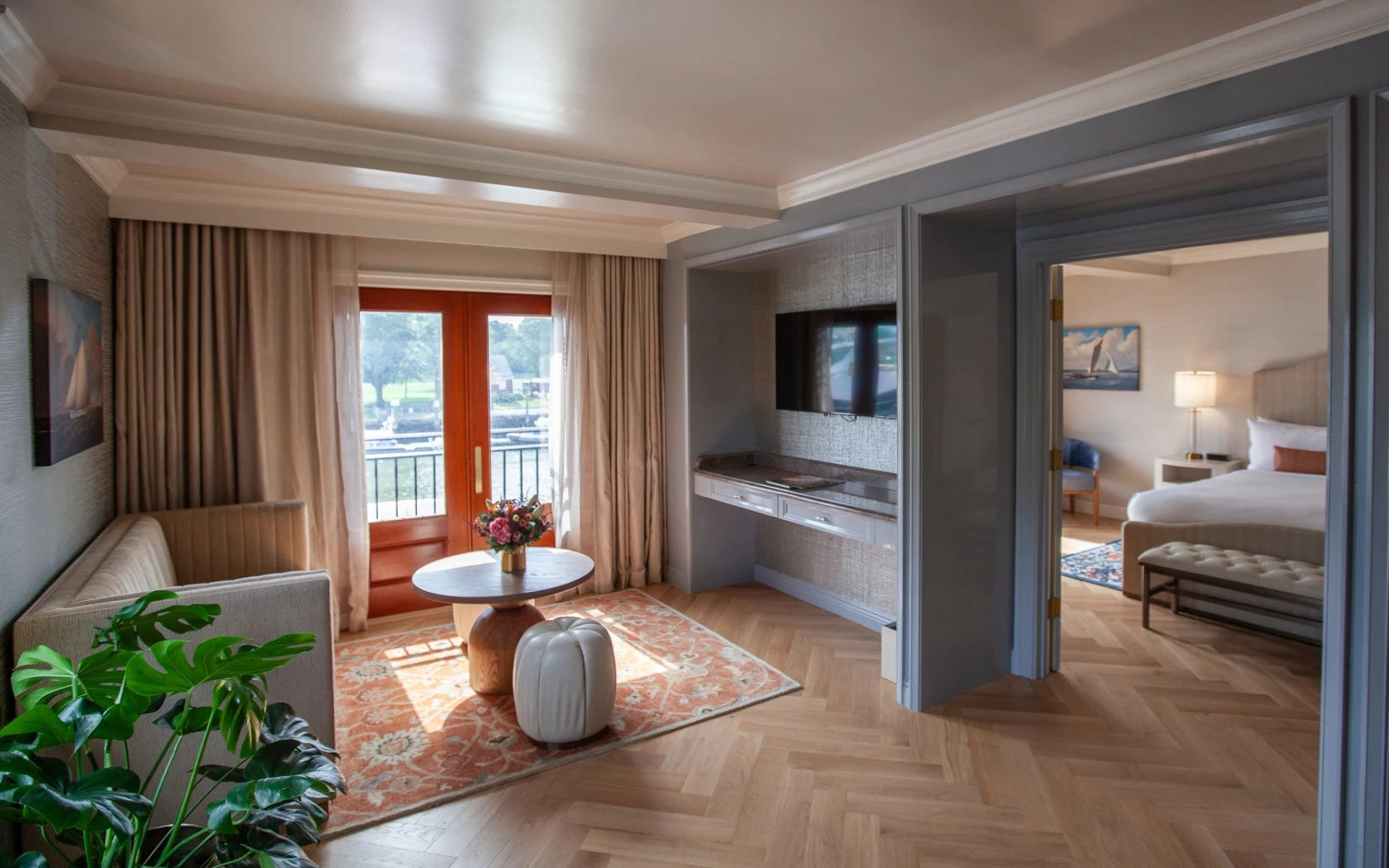 A wide view of a hotel suite with a living area and bedroom.
