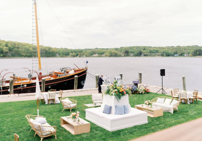a wedding reception area with a boat in the background
