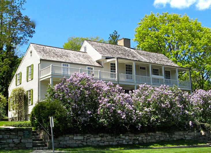 a house with a large porch and a large fence