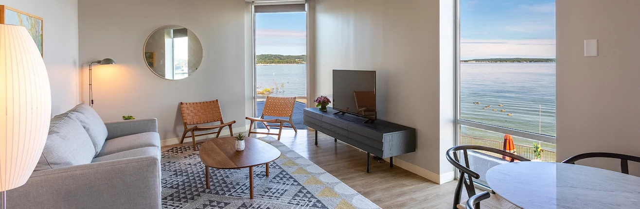 a living room with two large windows facing lake