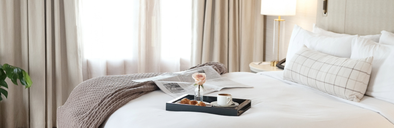 a tray of food and a cup of coffee on a bed