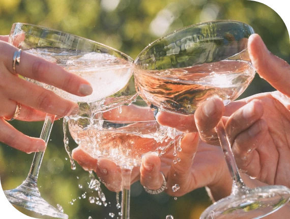 a group of hands holding wine glasses