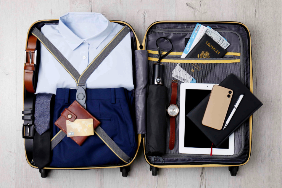 a suitcase with clothes and a tablet and a phone