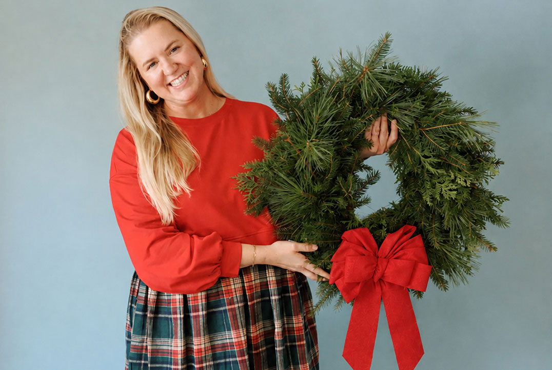 a woman holding a wreath