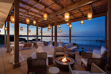 a patio with a fire pit and chairs