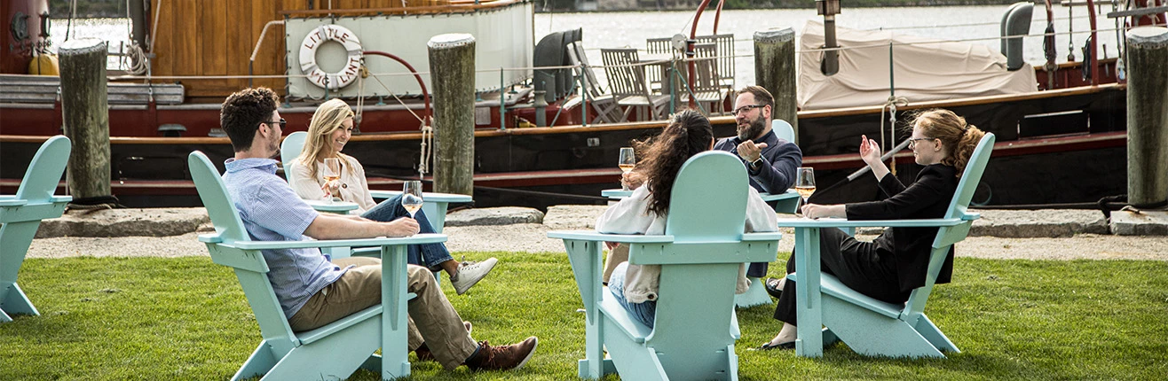 a group of people sitting at tables outside