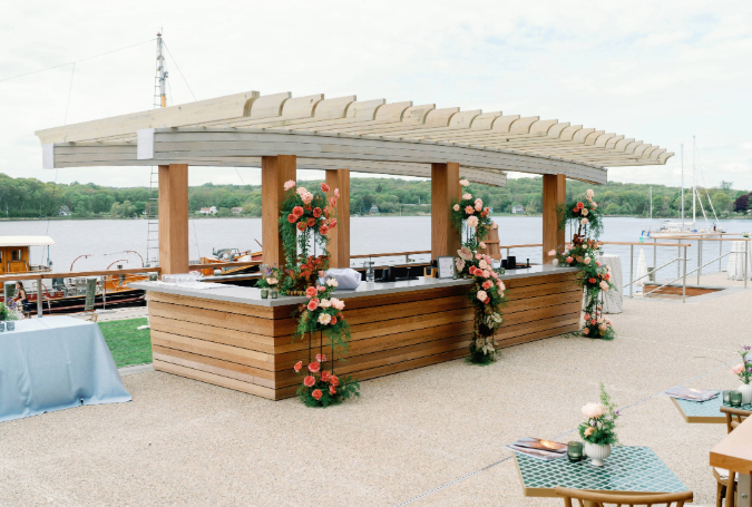a wooden bar with flowers and a table with a table and chairs