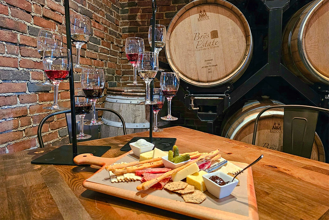 a wooden table with wine glasses and a tray of food