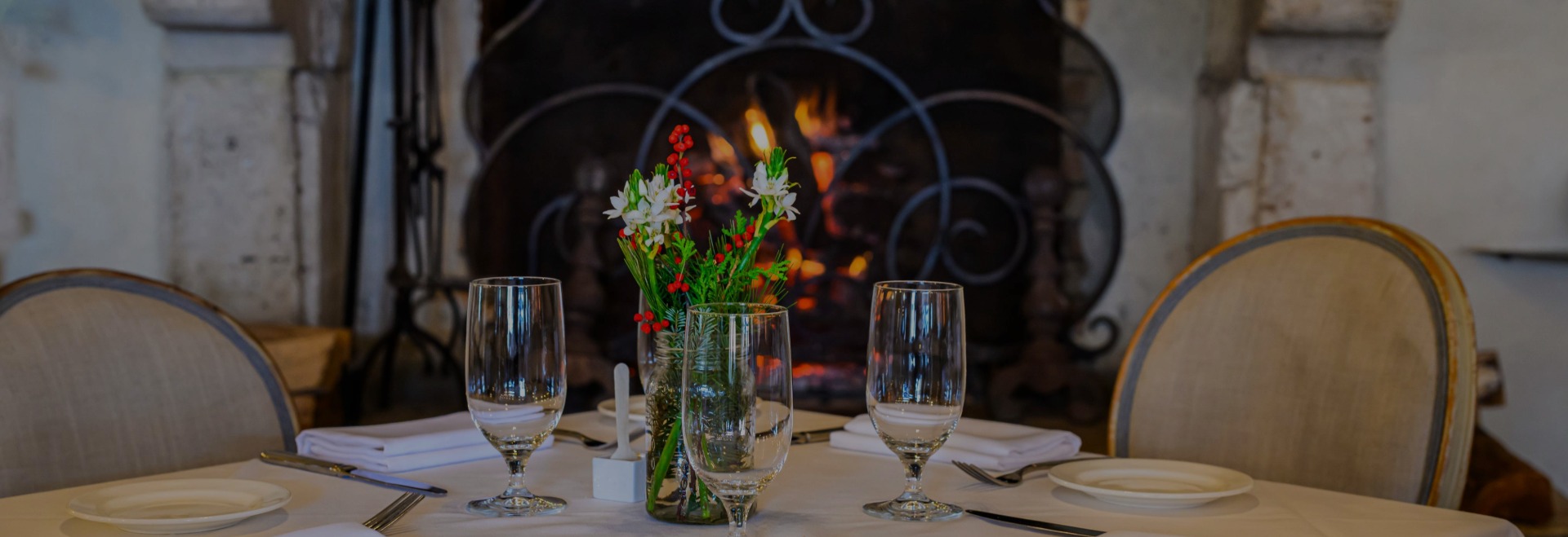 a table with glasses and a vase of flowers