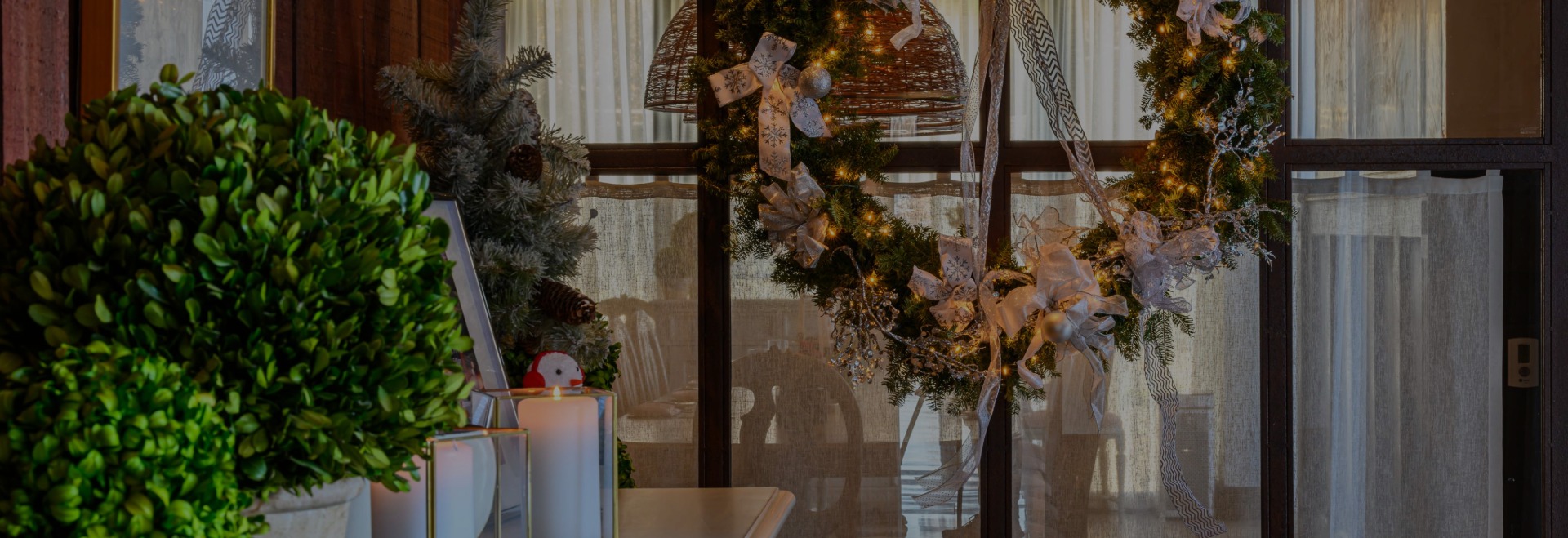 a christmas wreath and candles on a window