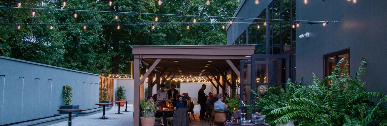 a group of people sitting at tables outside