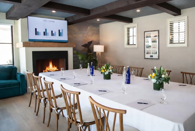a room with a fireplace and a table with wine glasses and flowers