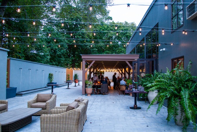 a patio with chairs and tables and lights