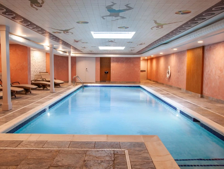 a indoor pool with a tile floor and a wall with a ceiling