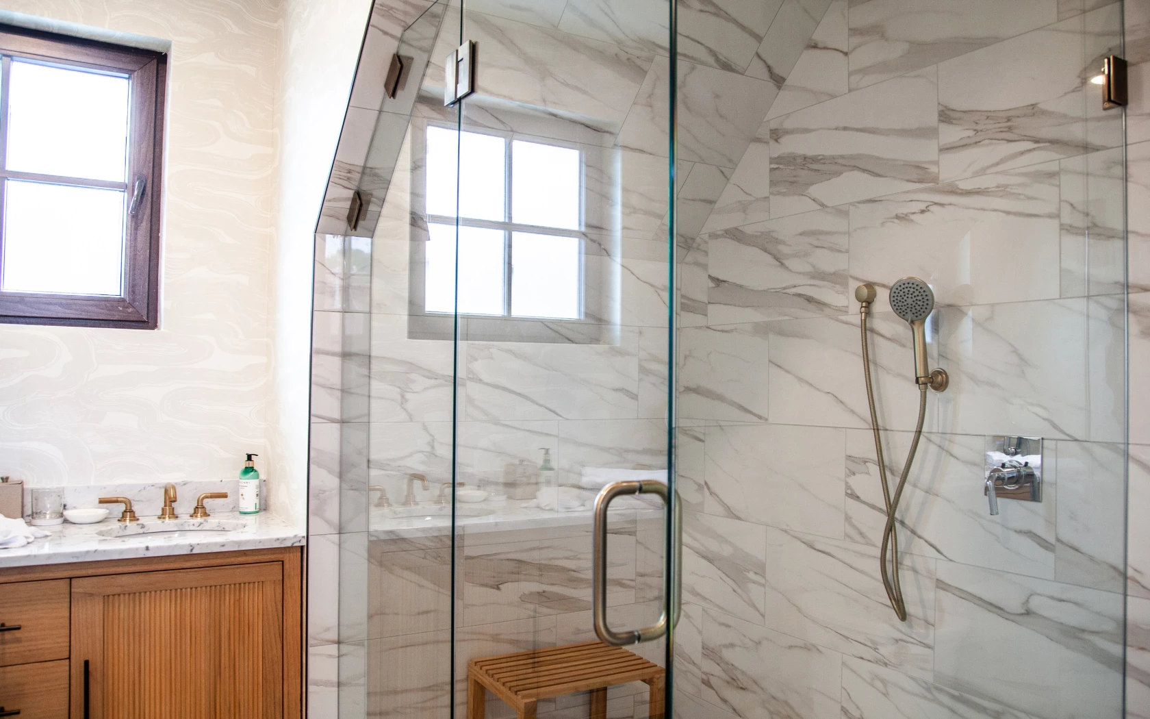 a bathroom with a shower, sink, and window