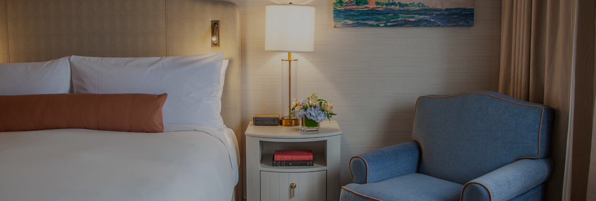 a lamp on a nightstand next to a bed